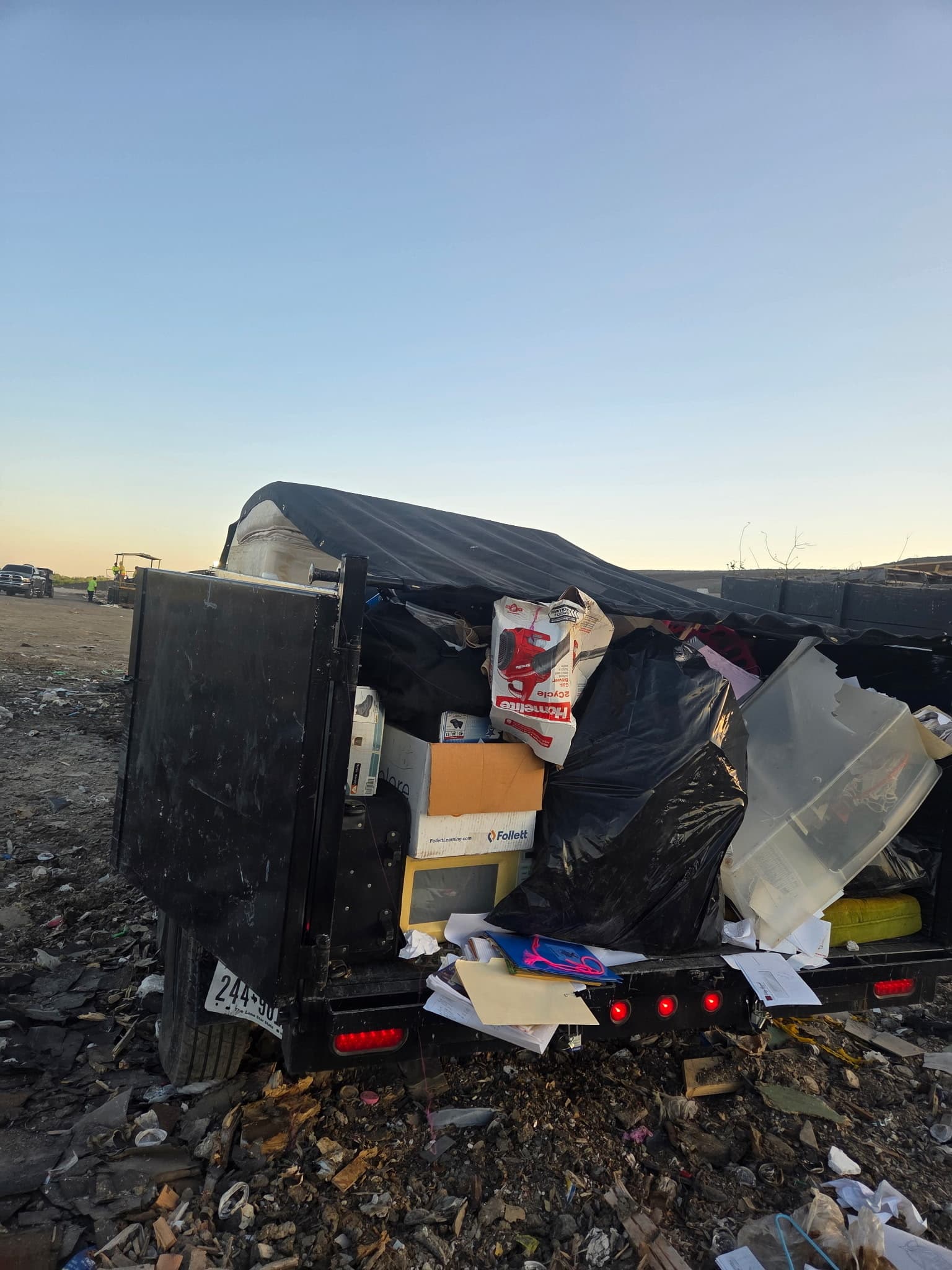 Full trailer from the Royse City storage cleanout at the landfill at dusk, gate open to unload